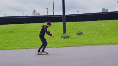 Guy pushes off with his foot, rolls on skateboard Stock-Footage 188496517