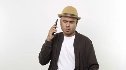 Guy put on hat in casual clothes talking on the mobile phone feel nervous isolat Stock Footage 144651506