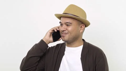 Guy put on hat in casual clothes talking on the mobile phone and nod isolated on Stock Footage 144651644