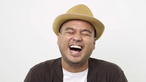 Guy put on hat in casual clothes is laughing and looking to the camera standing  Stock Footage 144651677