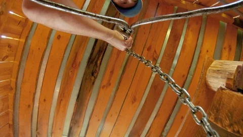 The guy puts a bucket on a chain at the bottom of the well for water intake. Stock Footage 113754113