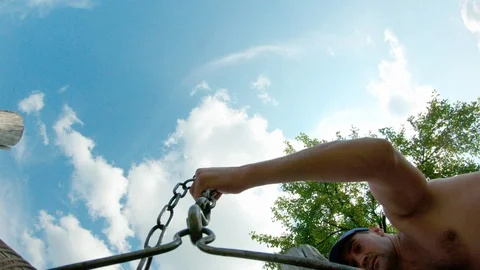 The guy puts a bucket on a chain at the bottom of the well for water intake. Stock Footage 113754200