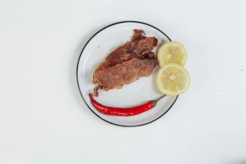 A guy puts dried meat in paper boxes in black gloves Stock Photos
