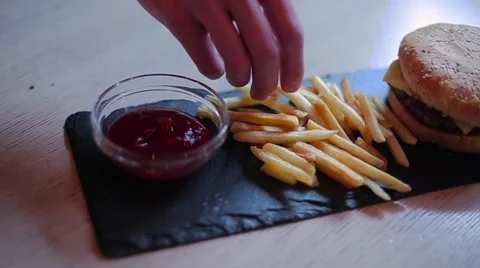 Guy puts fries in ketchup Stock Footage 61423406