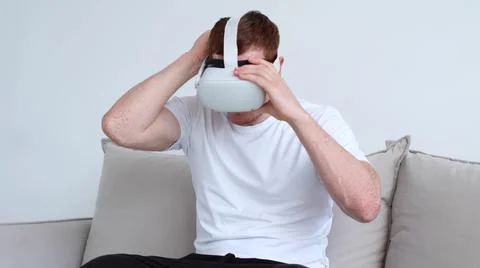 Guy puts on his head a virtual reality helmet. Handsome man wearing future Foto stock