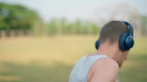 The guy puts on his wireless headphones, turns around and starts running Video stock 231336109