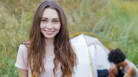 The guy puts the tent, while his girlfriend smiling Video stock 57104002