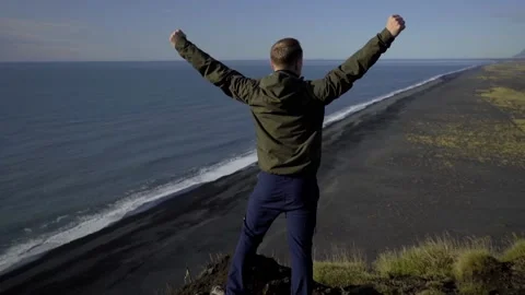 The guy raised his hands up celebrating a victory on top of the mountain. A man Stock Footage 130451827
