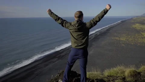 The guy raised his hands up celebrating a victory on top of the mountain. A man Stock Footage 131299879