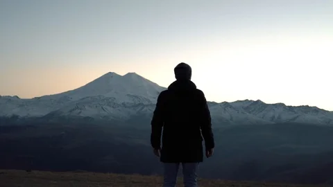 Guy raises his hands in the Mountain Ranges Stock Footage 98451021
