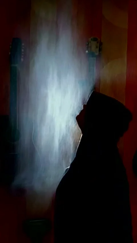 A guy in a raises his head with water drops against a background of guitars Stock Footage 328370485