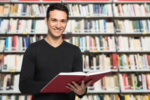 Guy reading a book in a library Stockfoto's