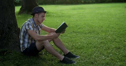 The guy is reading a book in the park. Stock Footage 52453334