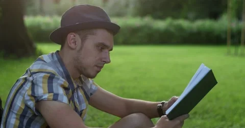 The guy is reading a book in the park. Stock Footage 52453455