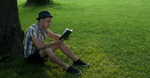 The guy is reading a book in the park. Stock Footage 52453539