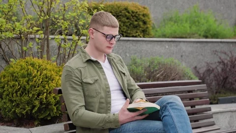 Guy Reading a Book in the Park Stock Footage 323925092