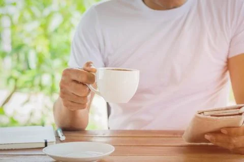 Guy reading interesting news while drinking coffee at home Stock Photos