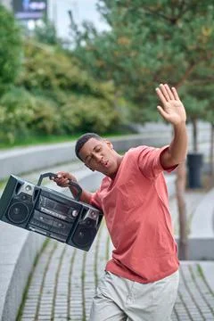 Guy with record-player in dance movement in park Stock Photos