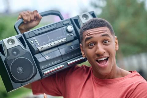 Guy with record-player on shoulder enthusiastically looking at camera Stock Photos