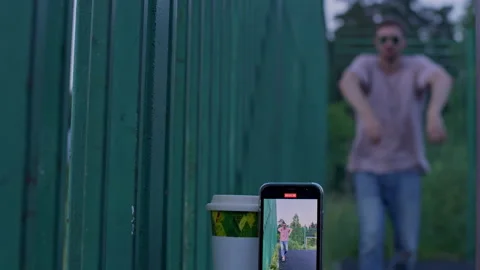 The guy records a video and dances in the evening Stock Footage 157426430
