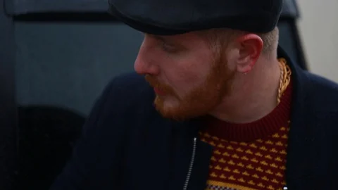 A guy with a red beard is talking and twirling a brass knuckles in his hands Stock Footage 128653504
