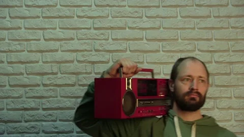 The guy with the red Boombox, adjusts different buttons and goes to the left Stock Footage 131170816
