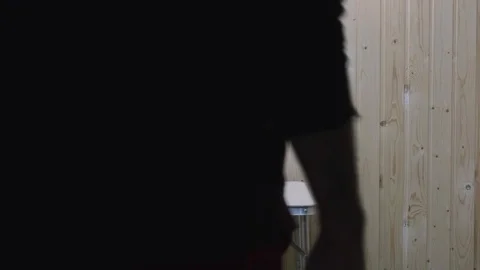 A guy in red clothes comes to a folding table in the room takes the Cup Stock Footage 119545749