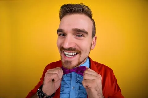 Guy in red jacket corrects tie and smile Stock Photos