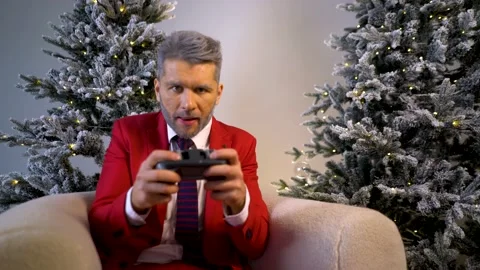 A guy in a red suit holds a game joystick in his hands. Video stock 167650037
