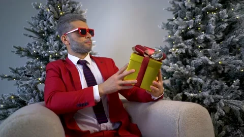 A guy in a red suit shows a gift for the new year. Beautiful Christmas gifts. Stock Footage 167649399