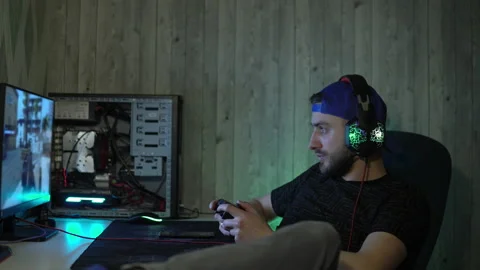 Guy relaxed in headphones plays computer games with a joystick Stock Footage 149218266
