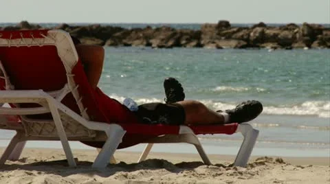 Guy relaxing at the beach Stock Footage 20506903