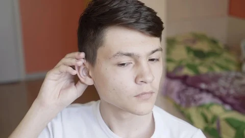The guy removes the hearing aid. Man with hearing aid Stock Footage 89441225