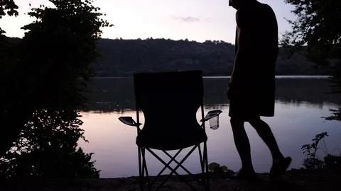 The guy is resting on the river bank, sitting on a folding chair Stock Footage 114631314