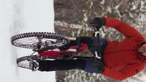 A guy rides a bicycle in a winter park Stock Footage 263578841