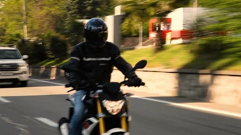 The guy rides a motorcycle with his hands up and not holding the steering wheel 库存影片 114556638