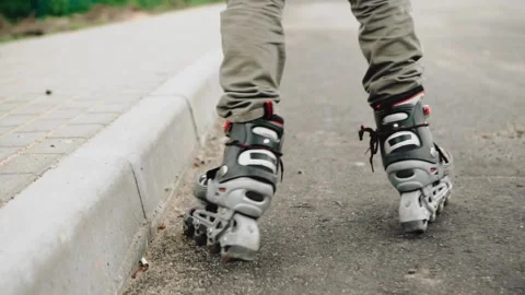 The guy rides on roller skates along the road along the sidewalk. Rear view Stock Footage 131281006