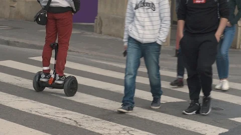 The guy rides on the sidewalk, standing on a hoverboard. Walk on the hoverboard. Stock Footage 107269435