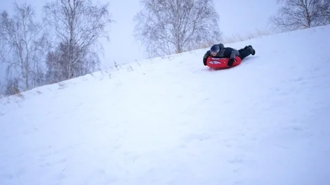 A guy rides a sled on a snowy mountain. Slow motion. Snowy winter landscape Vidéo 122249855