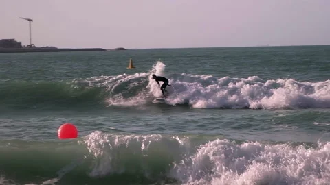 A guy rides the waves, a man trains to surf Stock Footage 234446317