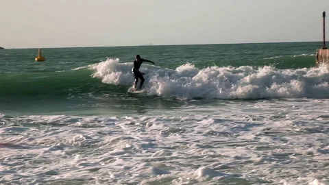 A guy rides the waves, a man trains to surf Stock Footage 234446401