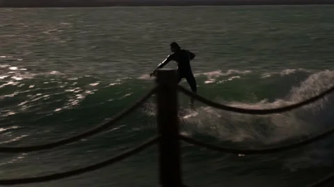 A guy rides the waves, a man trains to surf Stock Footage 234990604
