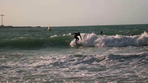 A guy rides the waves, a man trains to surf Stock Footage 235934296
