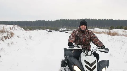The guy is riding an ATV on a snow-covered road in winter Vídeo Stock 84954118