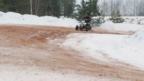 The guy is riding an ATV on a snow-covered road in winter 库存影片 84958225