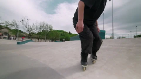The guy on roller skates in the skatepark does tricks. Stock Footage 199839041