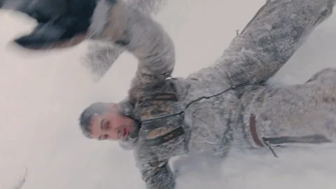 A guy rolls down a high hill in winter, tumbling and hitting a snowy slope. Video stock 327716971