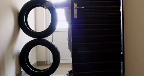 Guy rolls out tires placing elements on top of each other Stock Footage 294603888