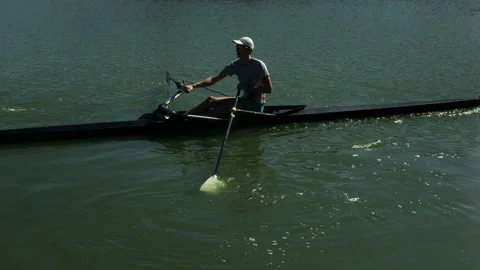 A guy rowing in a kayak in a race on a hot summer day on the river Stock Footage 159235261