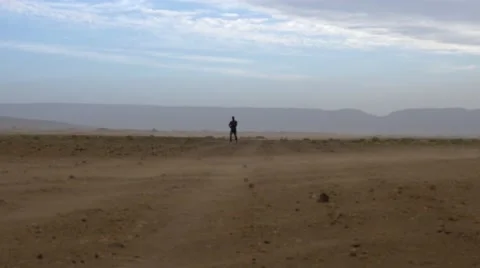 Guy running across the desert of morocco Video stock 67558692